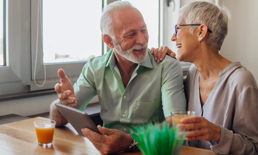 Elderly couple emailing and laughing