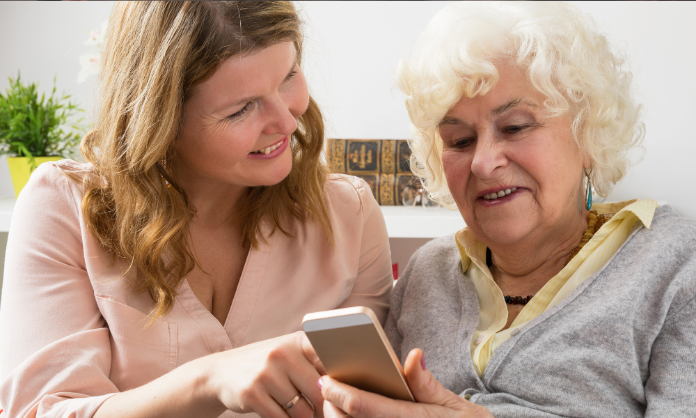 Daighter helping elderly mother respond to an email on her phone