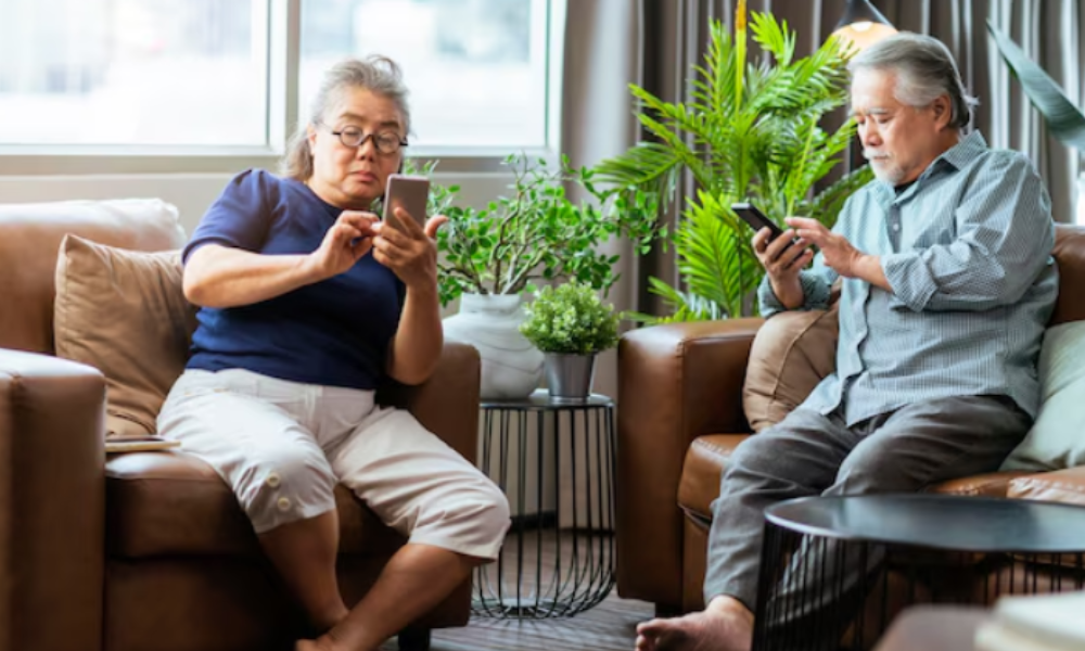 2 asian seniors checking their phones