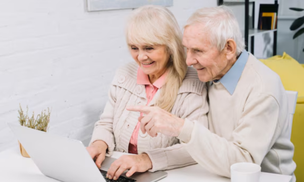 elderly couple sharing a laptop screen